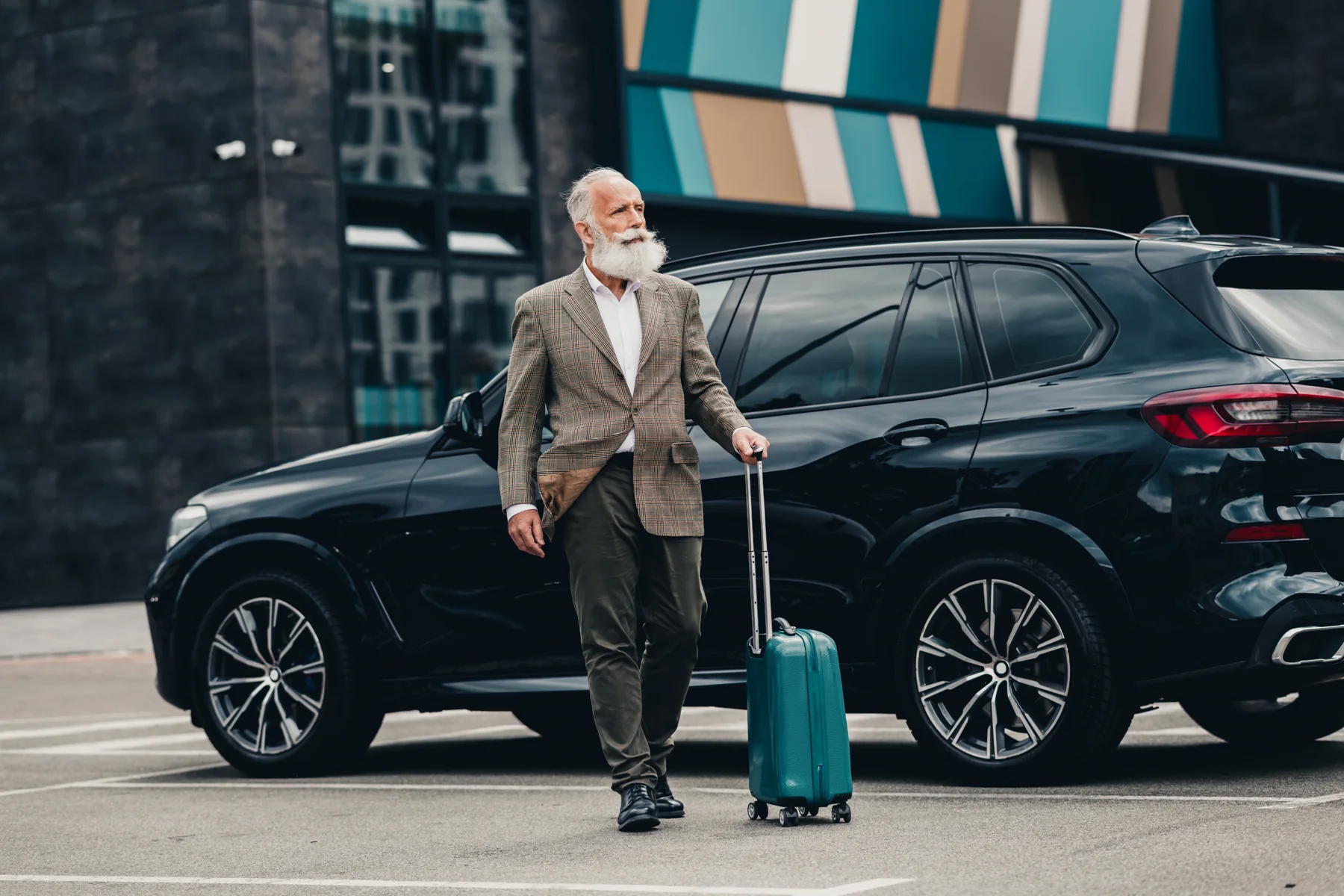 Business traveler with luggage beside a premium transportation vehicle